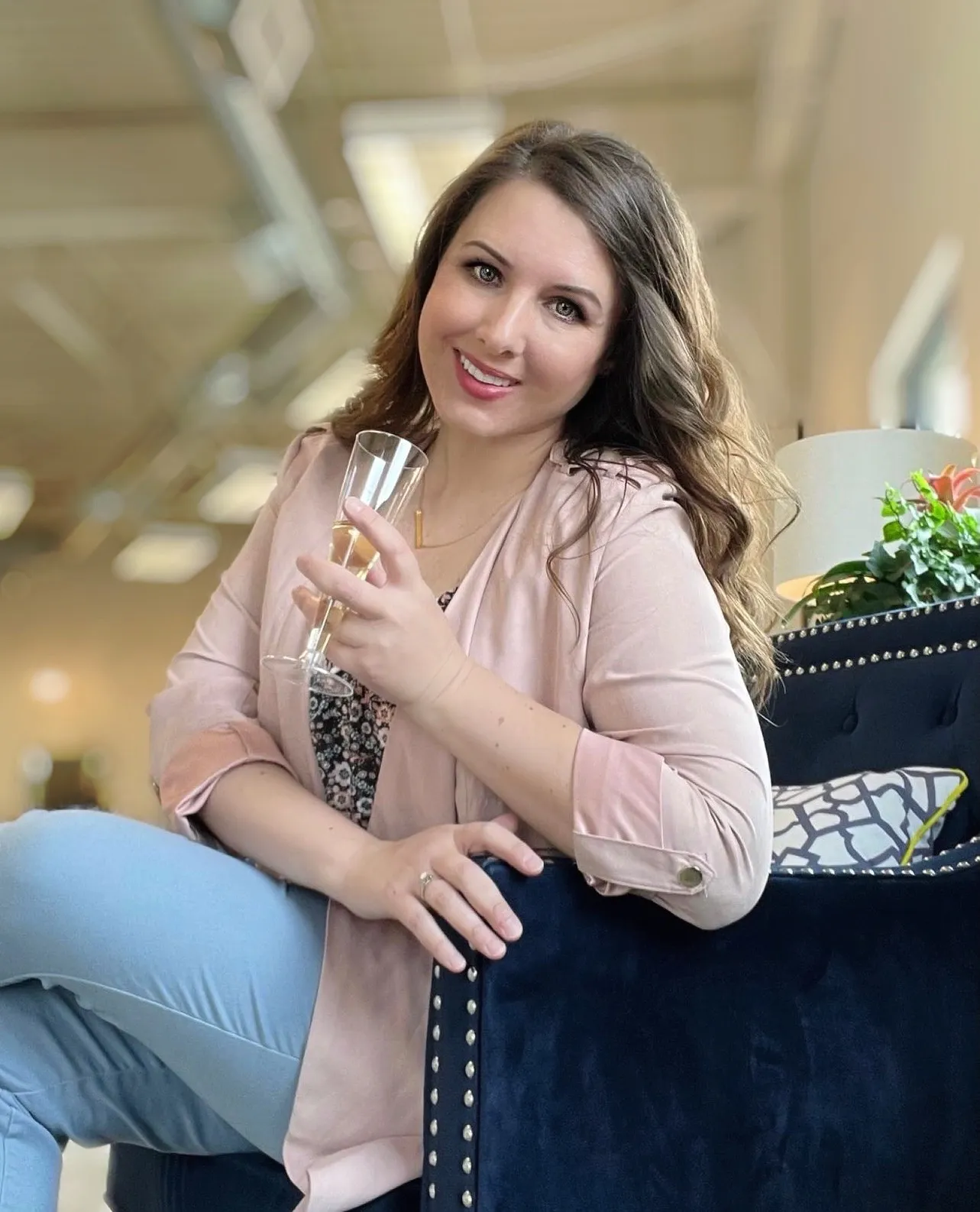Stephanie Gudowski seated with a glass, in her portrait published on BE engagement's about page